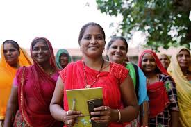 Smiling rural women holding books — district development and education programme beneficiaries